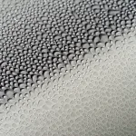 Dark gray car hood with patchy beading and dull reflections under natural light